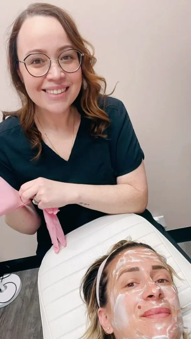 A woman is smiling while cutting her hair.