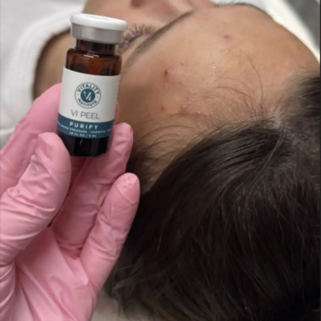 A person holding an ampoule of medicine over their head.