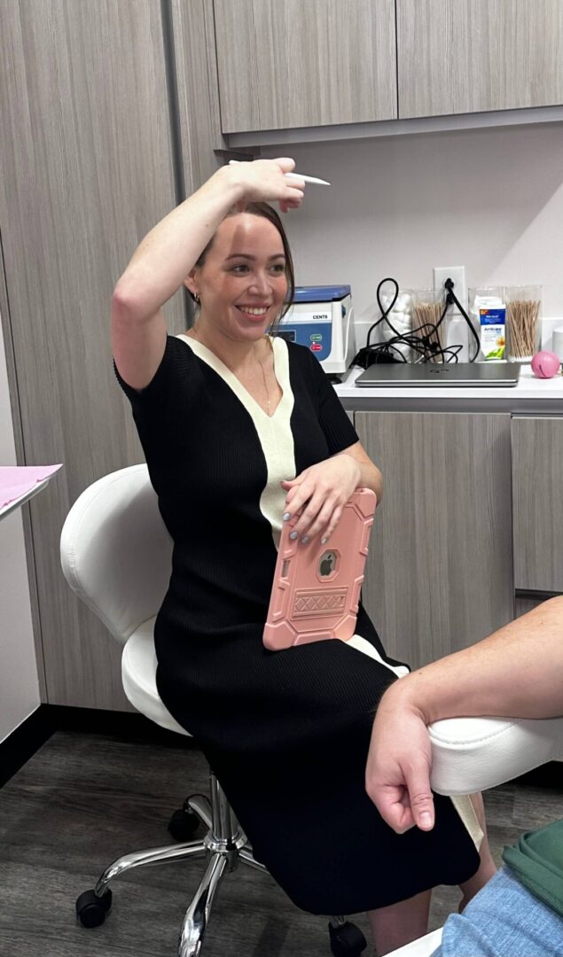 A woman sitting in a chair with her hand up to the side.